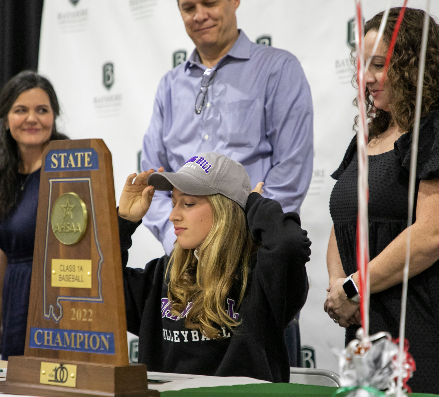 Ashlyn Whiteside dons the cap of her new volleyball team after she signed her National Letter of Intent to join the Spring Hill Badgers’ indoor and beach volleyball squads at a Nov. 30 signing ceremony at Bayshore Christian School. The two-time all-state honoree was part of the Eagles’ 2020 state championship squad.