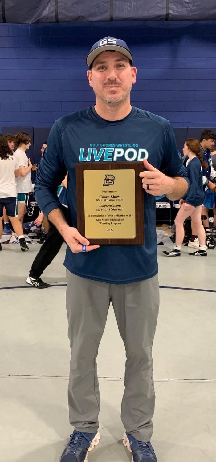 Gulf Shores head wrestling coach Britt Shaw was recognized Thursday, Dec. 8, after he collected his 100th dual match victory for the Dolphins with wins over W.S. Neal and LeFlore. Shaw took over the program in 2019 and led the team to the semifinals of the AHSAA state dual tournament last season.