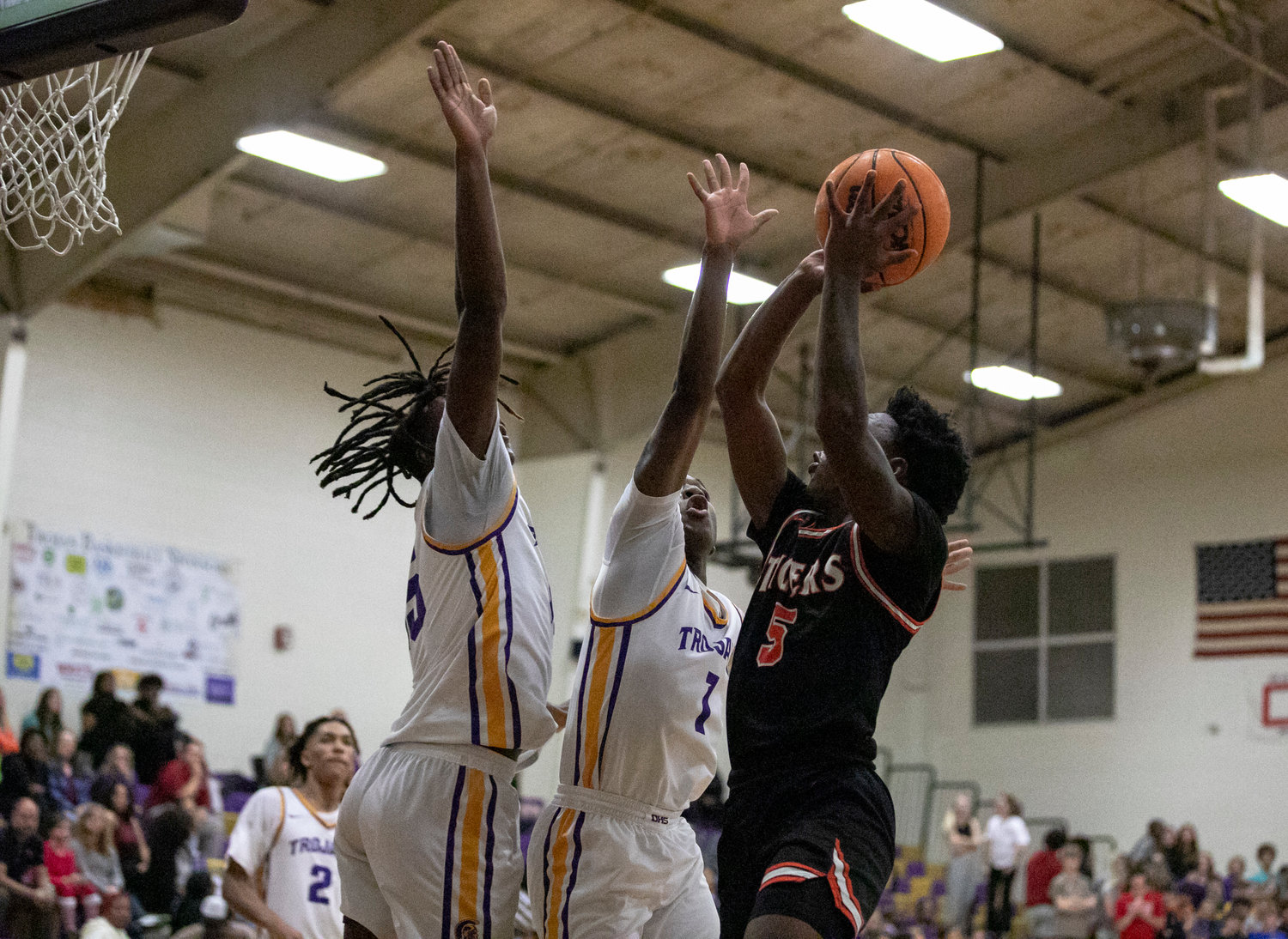 Baldwin County senior Tahjrick Bradley lifts a shot over a pair of Daphne defenders during the Tigers’ non-area road contest against the Trojans Tuesday, Dec. 13. Bradley recorded a team second-best 12 points as one of two Baldwin County scorers in double digits.