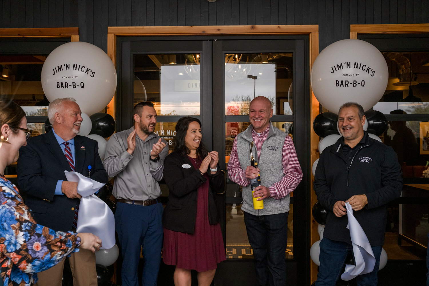 Brian Lyman, President of Jim ’N Nicks Community Bar-B-Q, celebrates with members of the South Baldwin Chamber of Commerce and City of Foley after the ribbon cutting at their newest location on Highway 59.