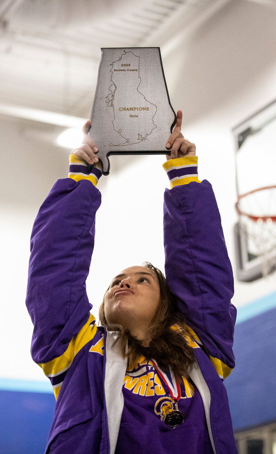 Daphne senior Kaylee Holder celebrates with the Baldwin County Championship trophy after the Lady Trojans won seven individual classes on top of eight more top-four finishes to stake claim as the top girls’ wrestling team in the county.
