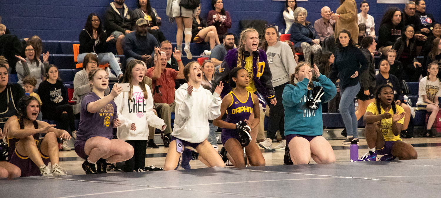 The Daphne Lady Trojans celebrate Taliah Wade’s semifinal win in the 152-pound class of the Baldwin County Championships at Gulf Shores High School Friday, Jan. 6. Wade was one of eight top-four finishers from Daphne that earned all-county honors.