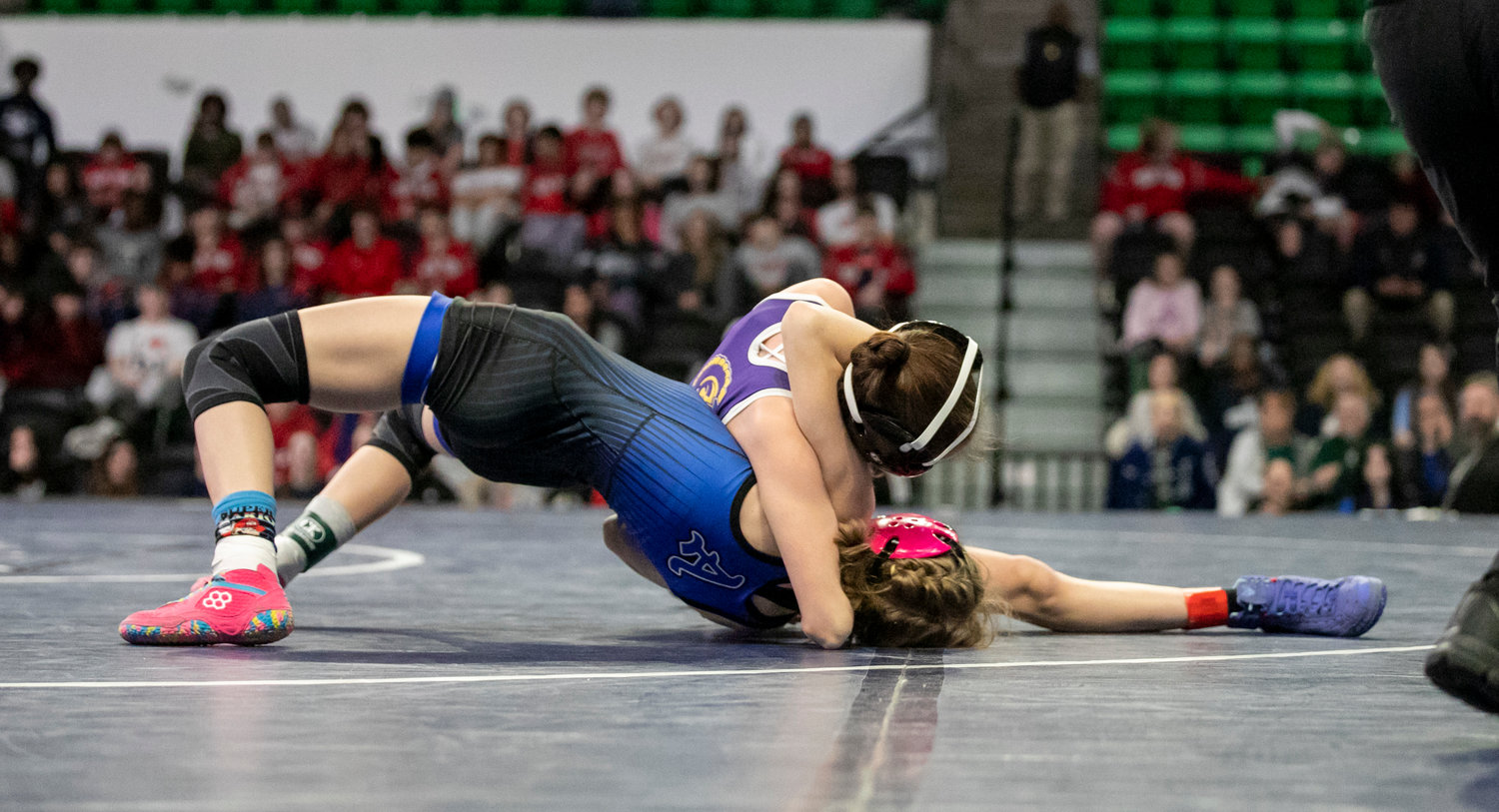 Lady Trojan Alanah Girard vies for a pin of Auburn’s Erin Clarkson during Friday’s state finals at Bill Harris Arena in Birmingham. After finishing as an individual runner-up last year, Girard returned home with a gold medal.
