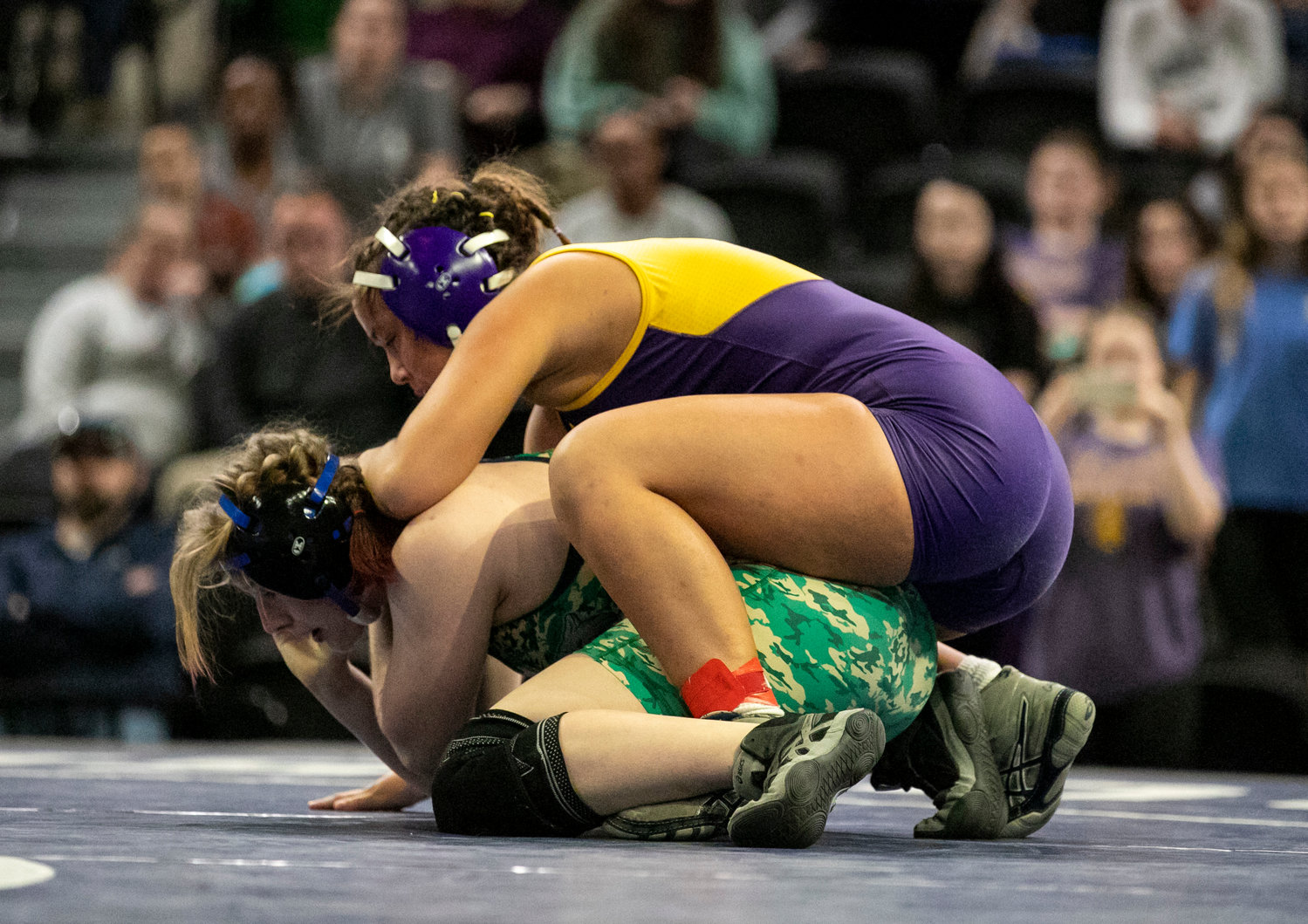 Daphne senior Kalee Holder works over Enterprise’s Mackenzie Schultz during the state final match at Bill Harris Arena in Birmingham Friday afternoon. The Lady Trojans’ 165-pounder earned a silver medal to help the squad take second in the team competition.