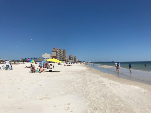 Visitors walk and sit on the public beach in Gulf Shores. Gulf Shores City Council plans to ban alcohol on city beaches during the 2023 spring break in March and April.
