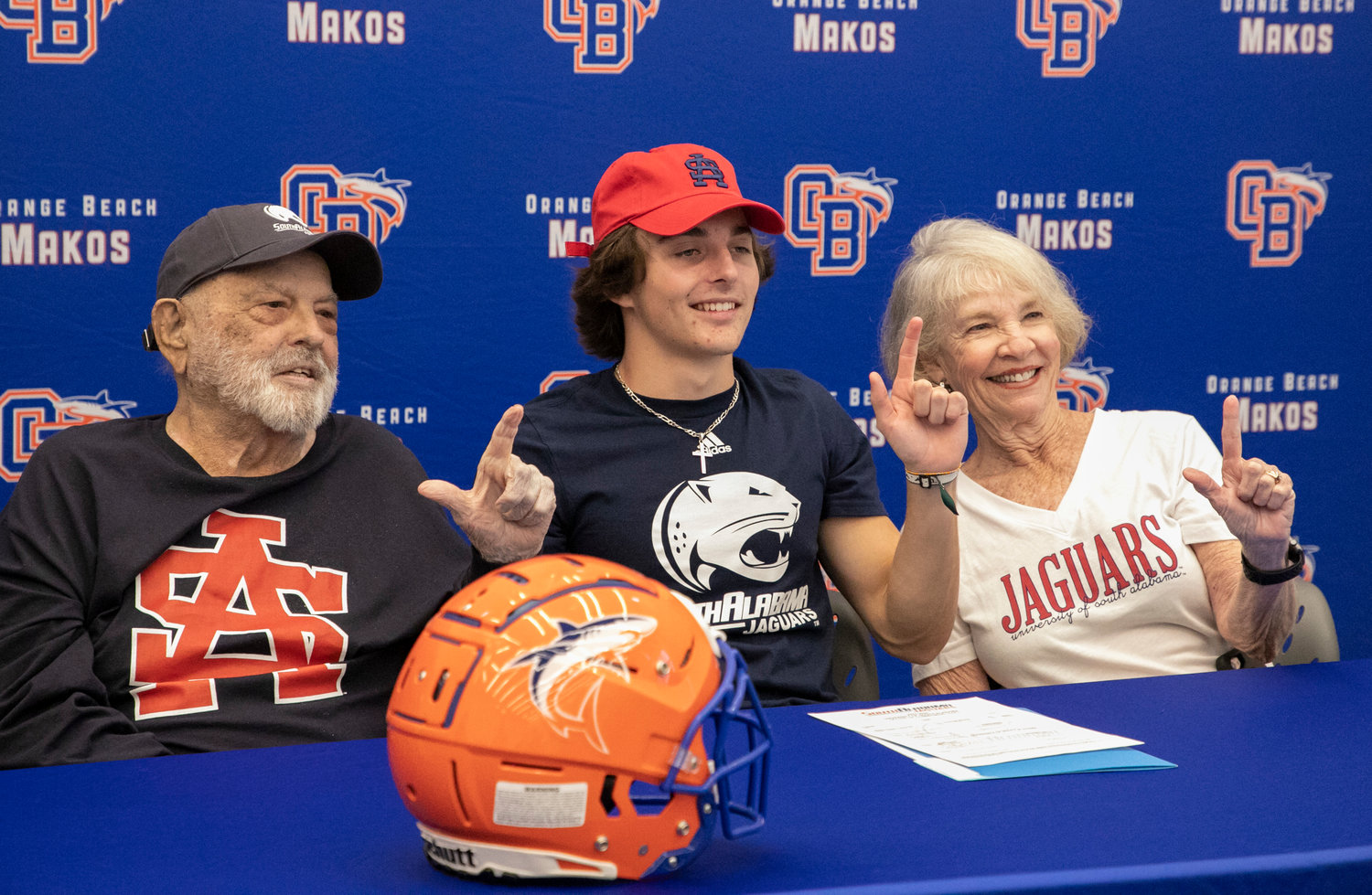 Orange Beach’s Cash Turner holds up the South Alabama “J” with his grandparents during the Feb. 1 National Signing Day ceremony at the high school where Turner signed with the Jaguars as a preferred walk-on.