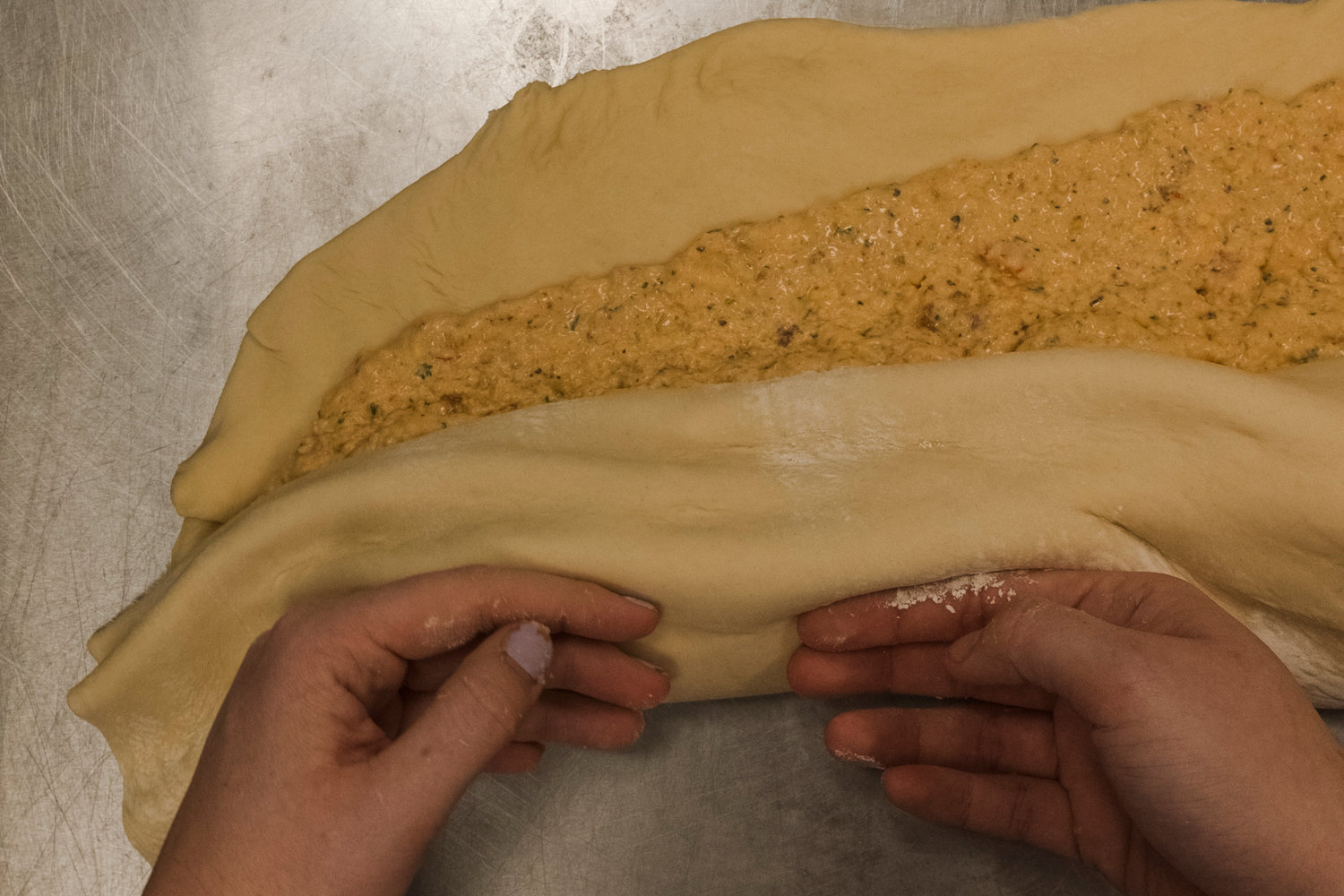 The crawfish king cake starts with freshly made dough that is spread with the crawfish filling. It is then rolled up and baked to golden perfection.