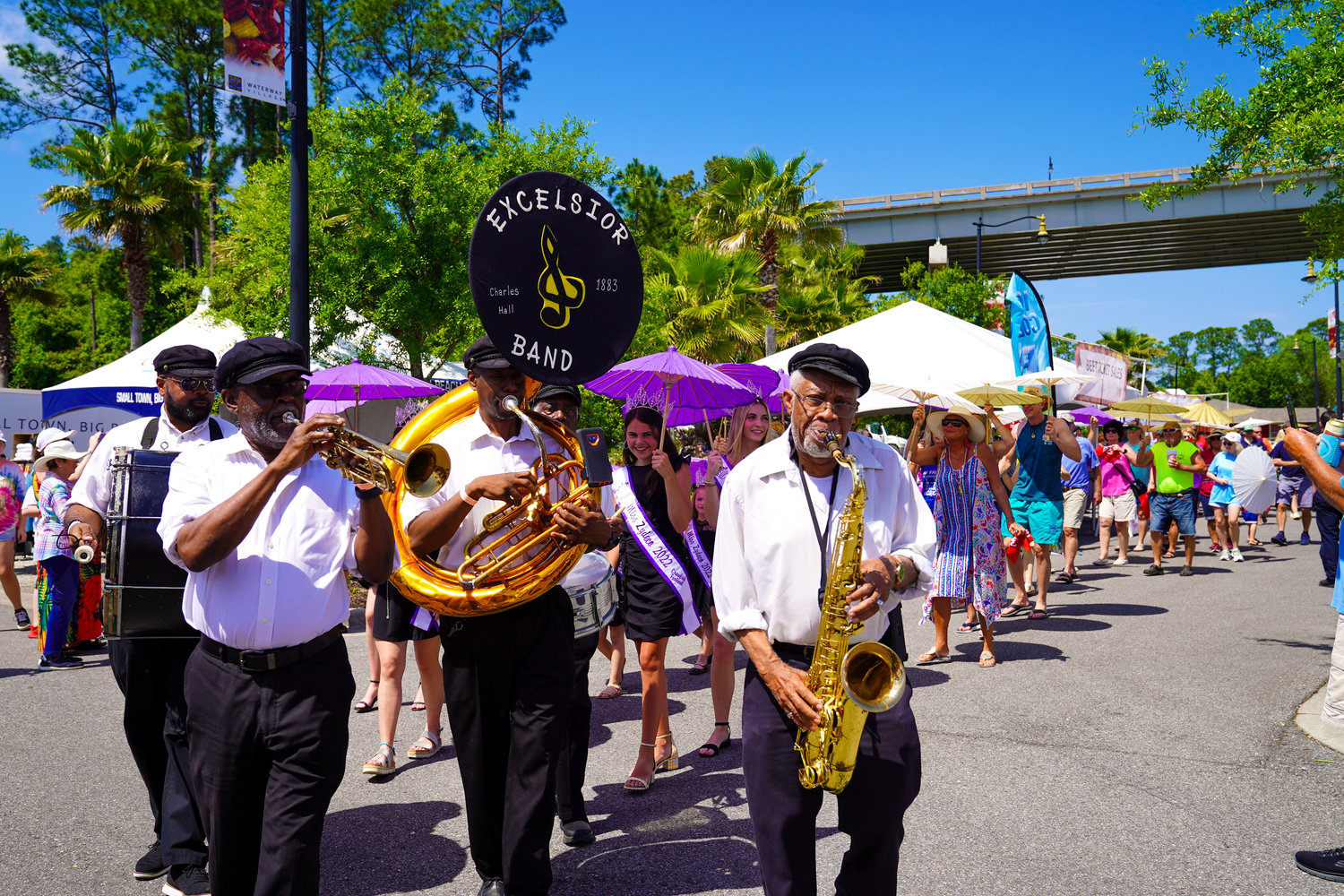 The Excelsior Band leads the second line through the Waterway Village.
