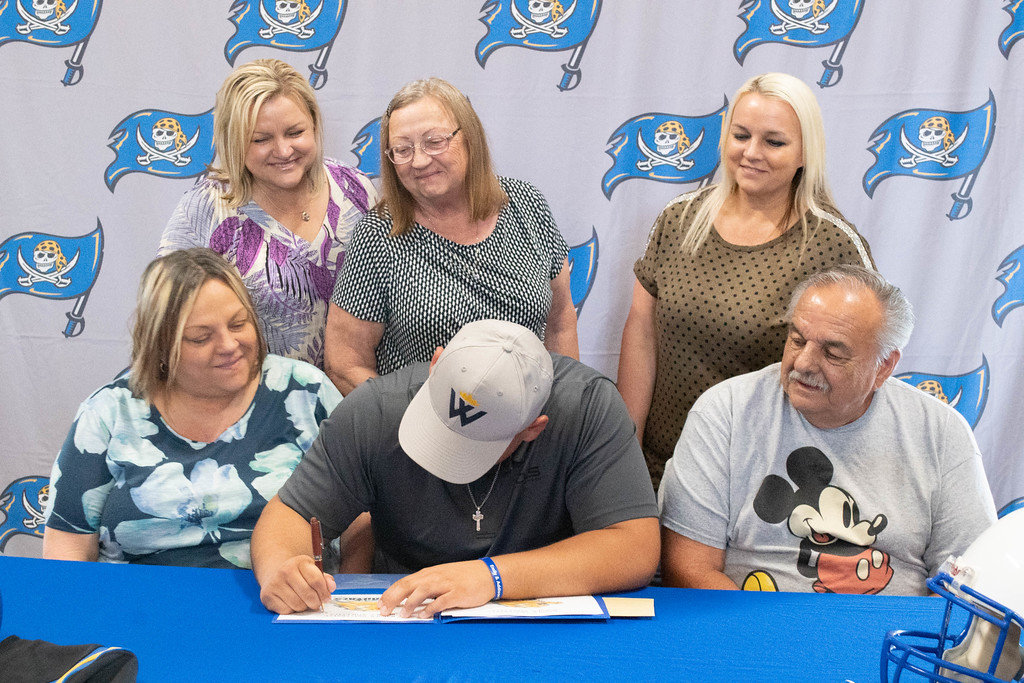 Fairhope senior Mickey Herrick puts pen to paper to cement his pledge to the Warner Royal football program during a signing ceremony at No Off Season training facility Sunday, March 12. Herrick helped the Pirates finish 8-3 for a sixth straight winning season in 2022.