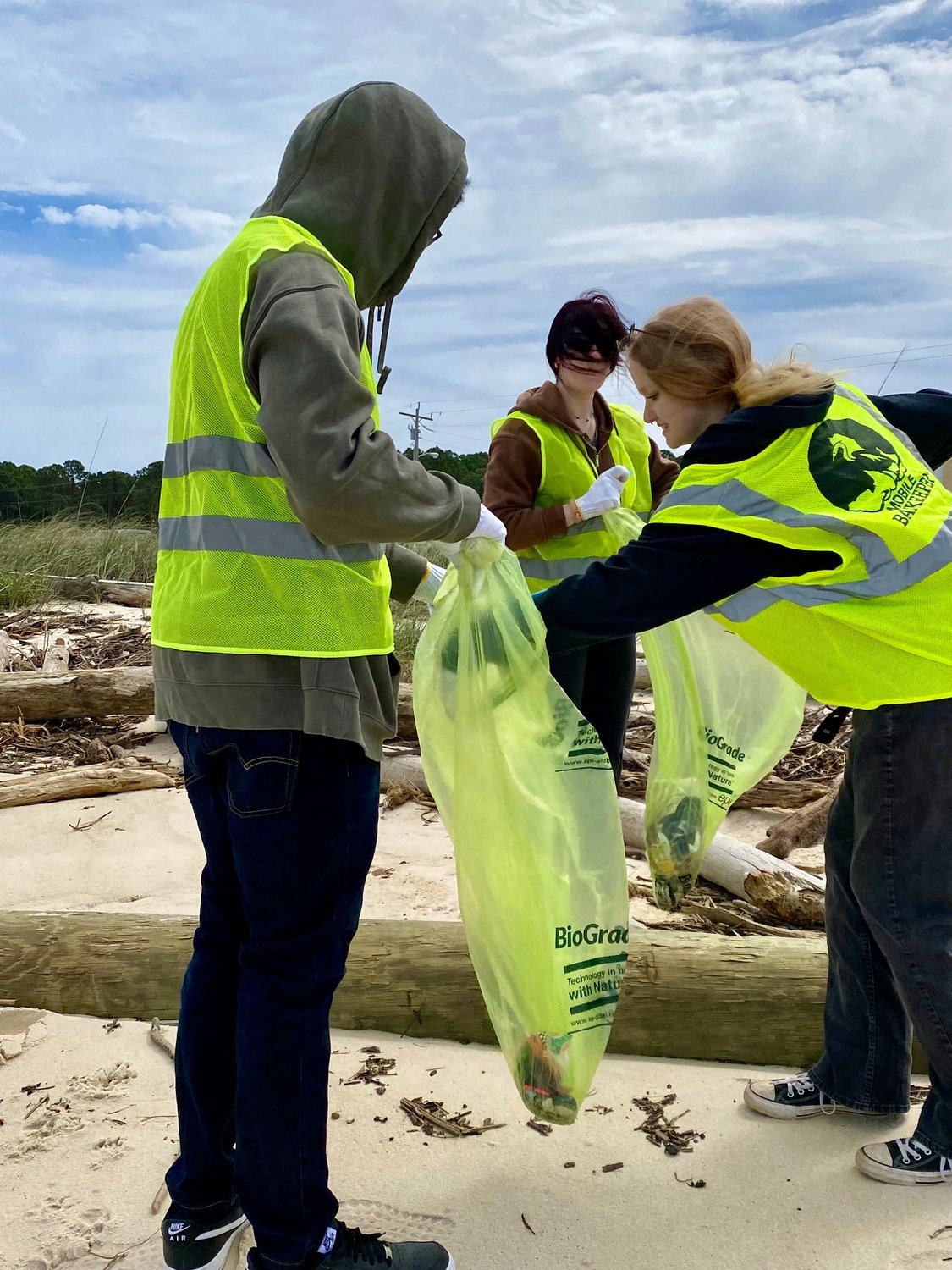 Emily Ammons, Jermaine Frye and Emily Whiddon, a group of friends from Mobile, volunteered to clean up the beach to get a chance at going to the Hangout Music Festival for the first time.