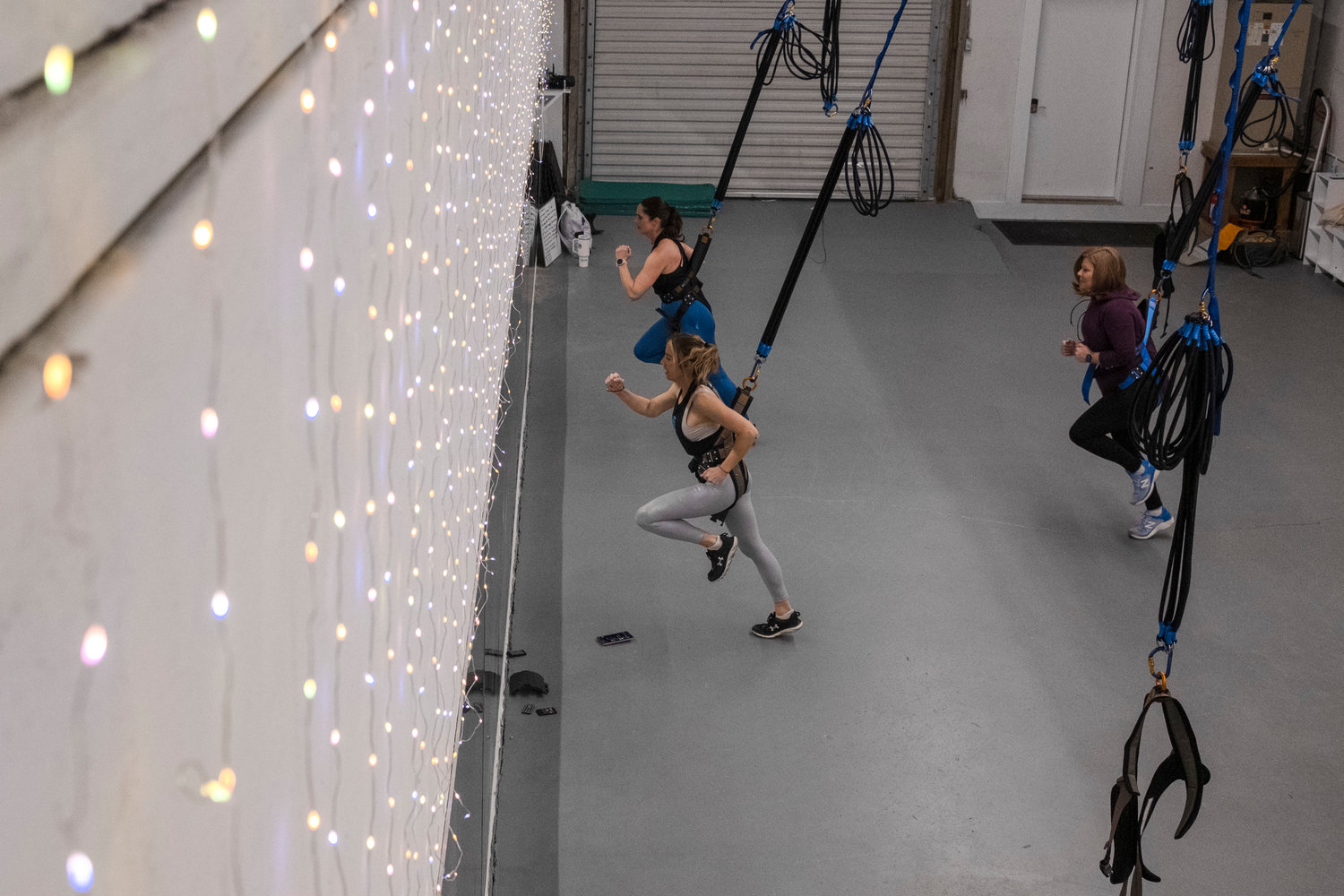 Jessica Watkins, owner of FIT Fairhope, leads Lauren Babcock and Melanie LeCroy in a Sling Bungee workout.