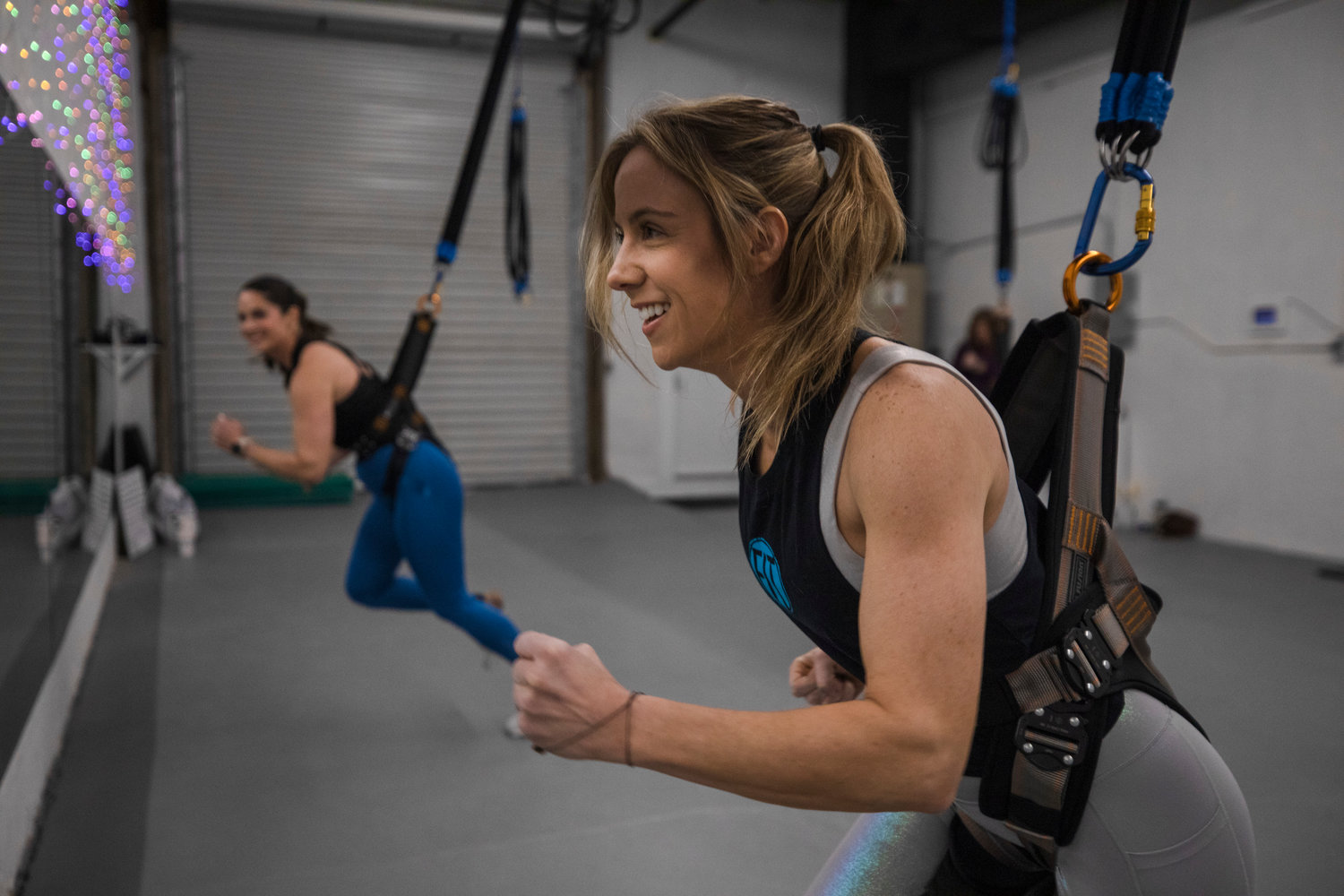 Jessica Watkins, owner of FIT Fairhope, leads Lauren Babcock in a Sling Bungee workout.