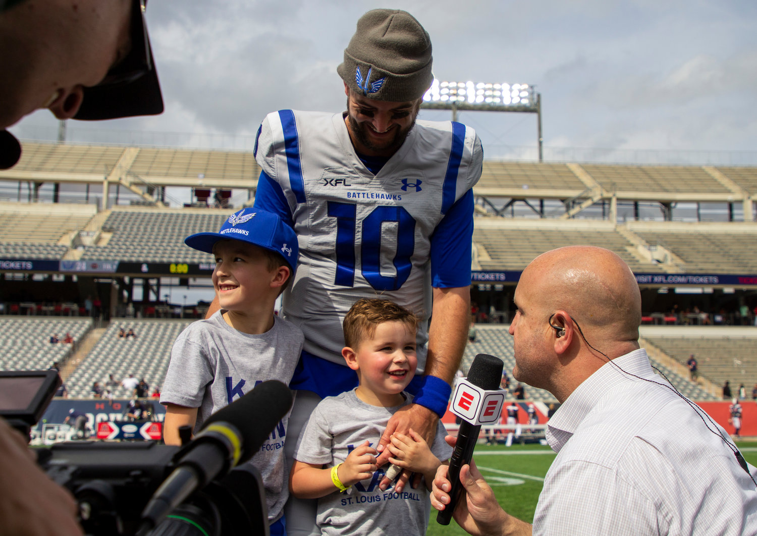 ESPN’s Cole Cubelic interviews Battlehawks quarterback AJ McCarron and his sons Cash and Gunnar after St. Louis’ victory at Houston’s TDECU Stadium Sunday, April 2. McCarron said priceless moments like these are the reason why he came back to play in the XFL instead of a higher-paying job in the NFL.