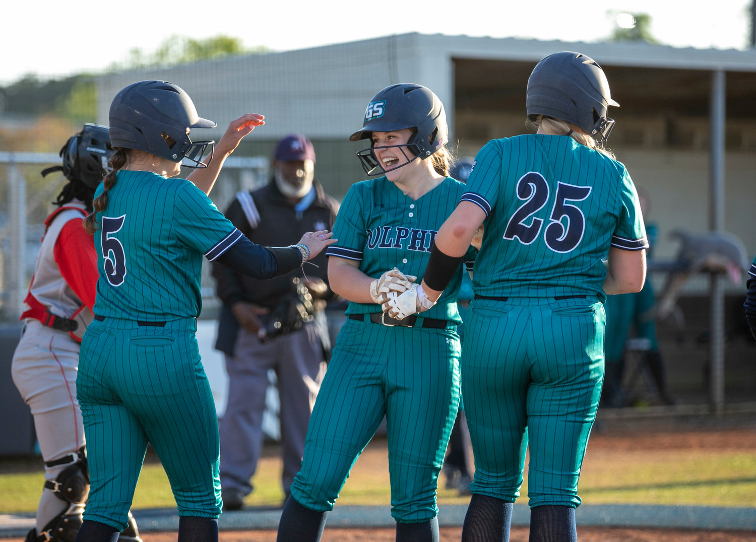 Gulf Shores eighth-grader Kayleigh Jacks celebrates her grand slam with freshman Anna-Leigh Price (5) and junior Emily Smith (25) during the Dolphins’ Class 5A Area 1 doubleheader against B.C. Rain at home March 21. After a 4-0 start, Gulf Shores had its final area contests scheduled earlier this week.