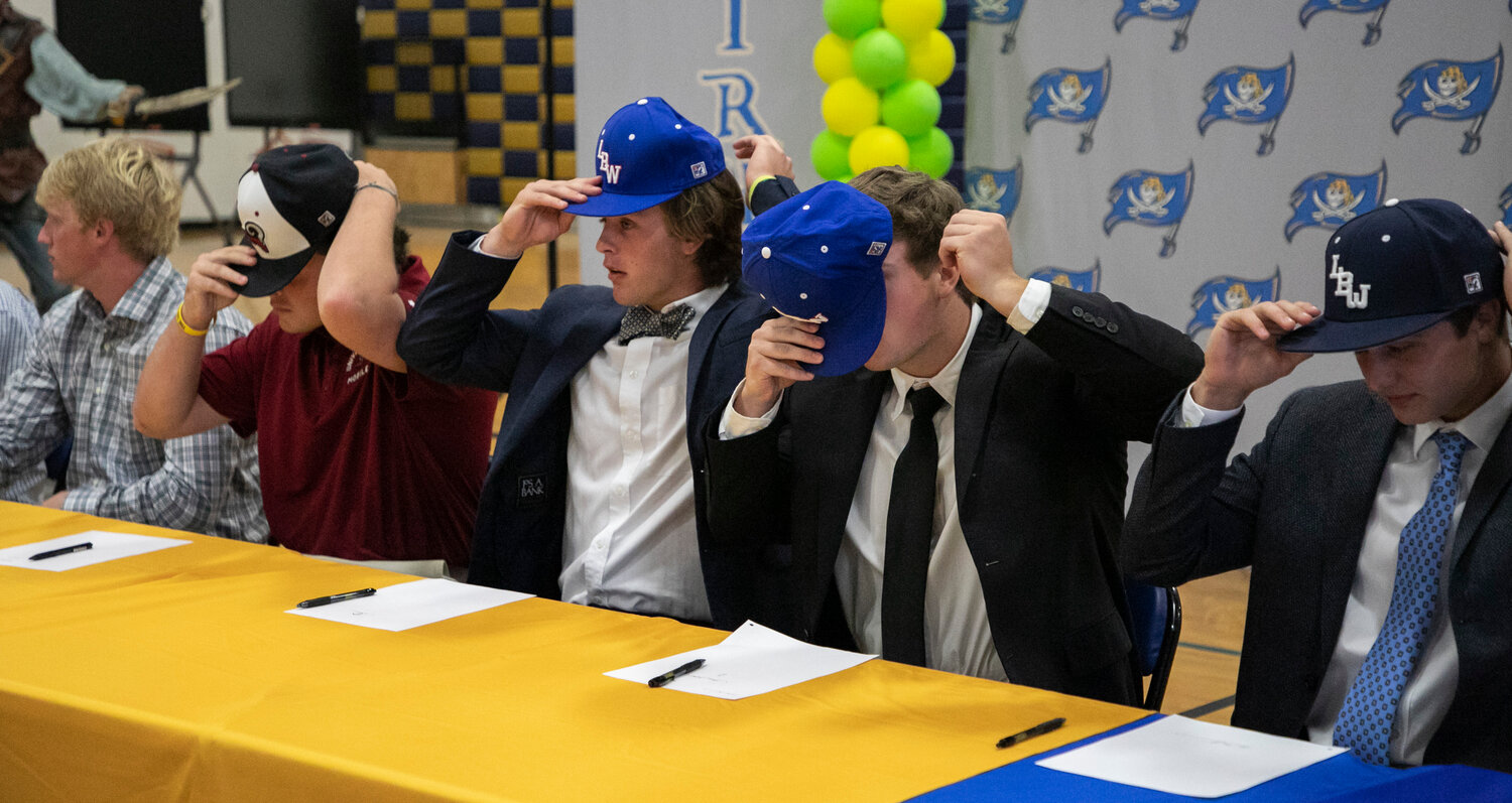 Fairhope baseball players don the hats of their next teams after they signed their National Letters of Intent Monday, April 17, in the high school gymnasium. Pictured from the left are Jacob Conway, a Mobile signee, and Lurleen B. Wallace signees Hollon Brock, Jackson Hatcher and Ben Moseley.