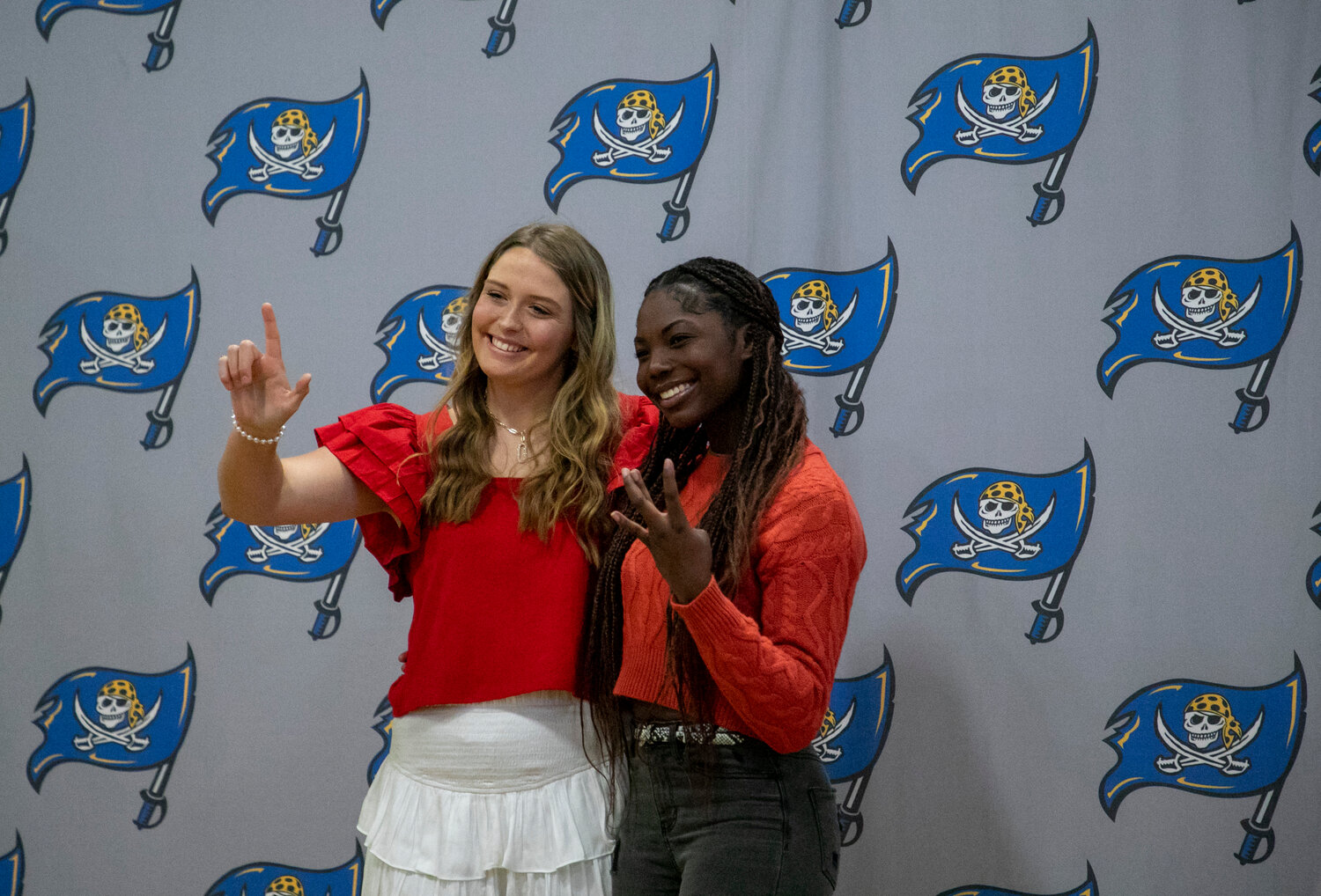 Softball players Ryley Harrison and Edy Gavin throw up the hand signs for their future colleges, South Alabama and Wallace State, after the April 17 signing ceremony at Fairhope High School. The pair of Pirates have helped their team to a No. 4 state ranking where both have registered a batting average over .400.