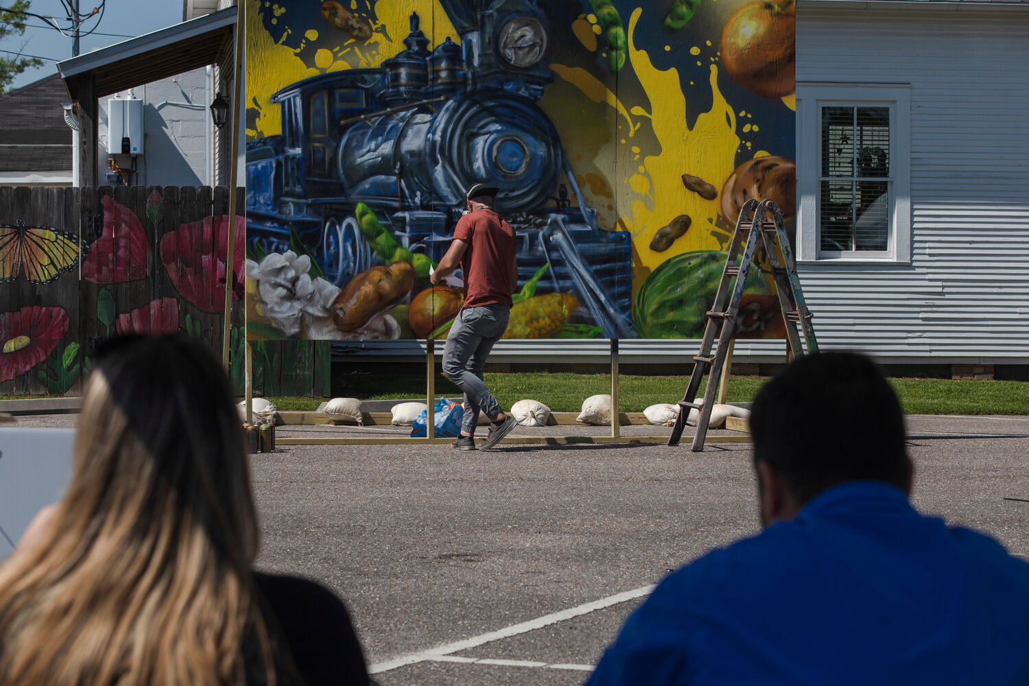 The artist known as ARCY spray paints a mural in six hours at the CATalyst event in downtown Foley.