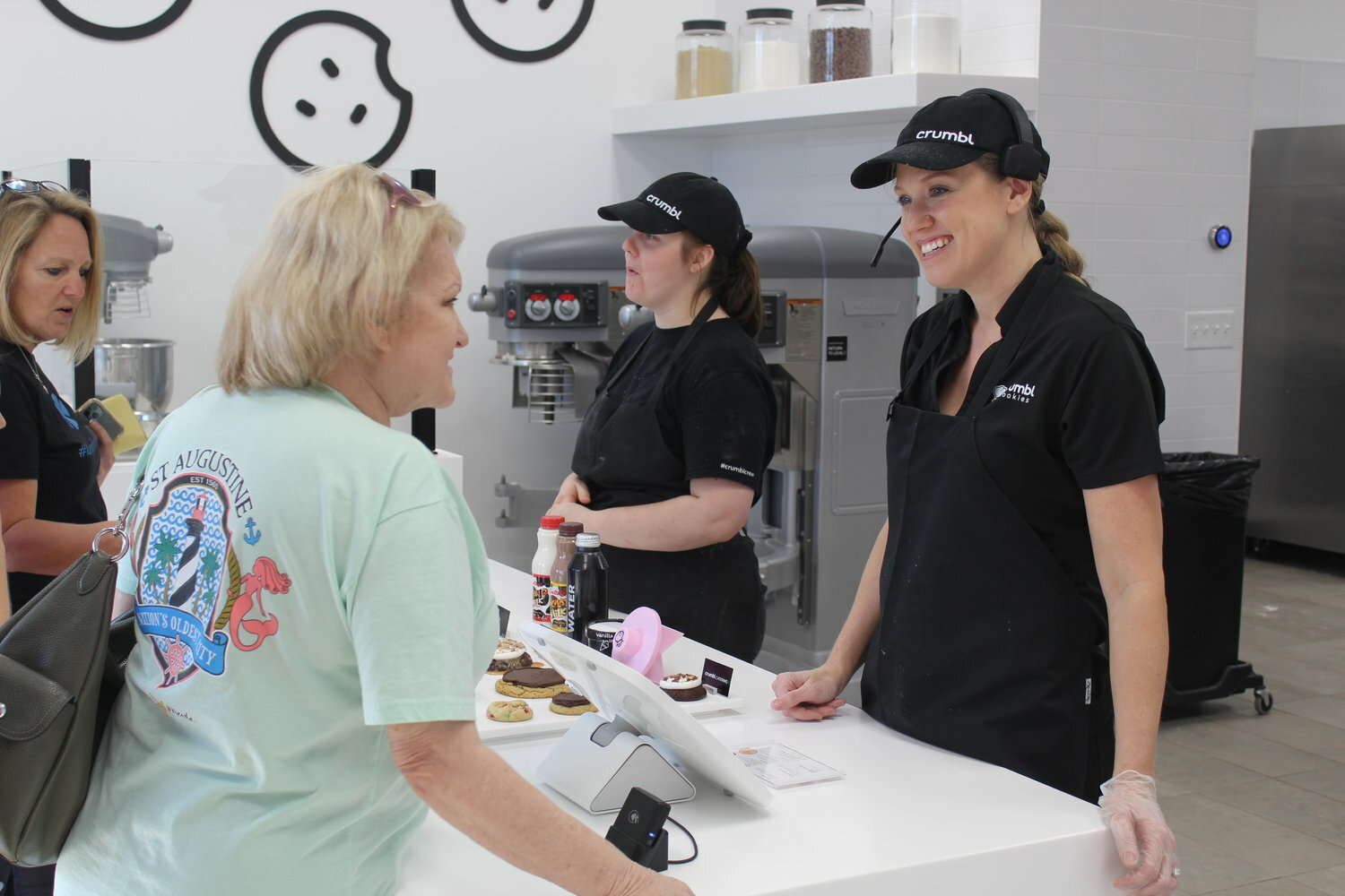Kayla Roof, co-owner of Crumbl Cookies Daphne and Spring Hill greets a customer in the Daphne store.