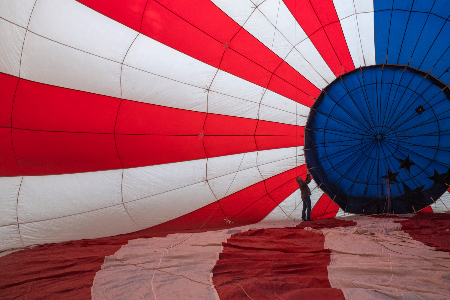 Gary Brossett, a hot air ballon pilot and crew member, checks the interior of “Stars & Stripes”, Rusty Miller’s balloon, before a flight outside of Atmore.