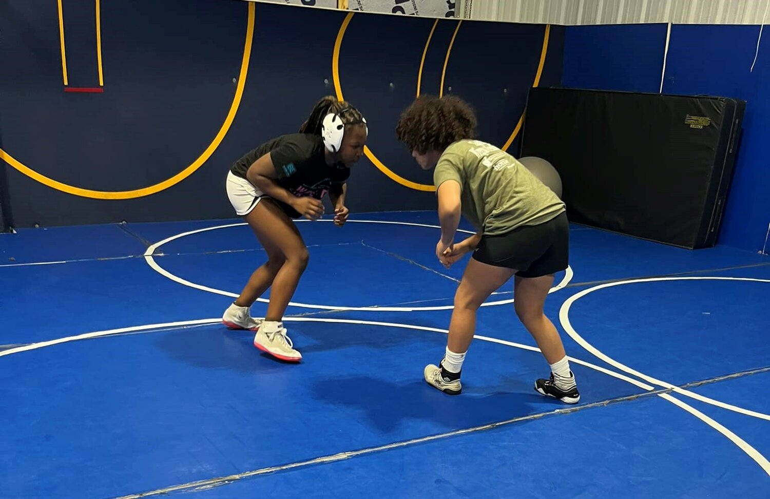 Two-time state champion Kalyse Hill from Daphne works with three-time state champion Evelyn Holmes-Smith from Enterprise at Assassins Wrestling Club on July 5 in preparation for last weekend’s U.S. Marine Corps USA Wrestling 16U and Junior Nationals. Holmes-Smith went on to record a fourth-place finish in the 122-pound bracket to earn All-American status.