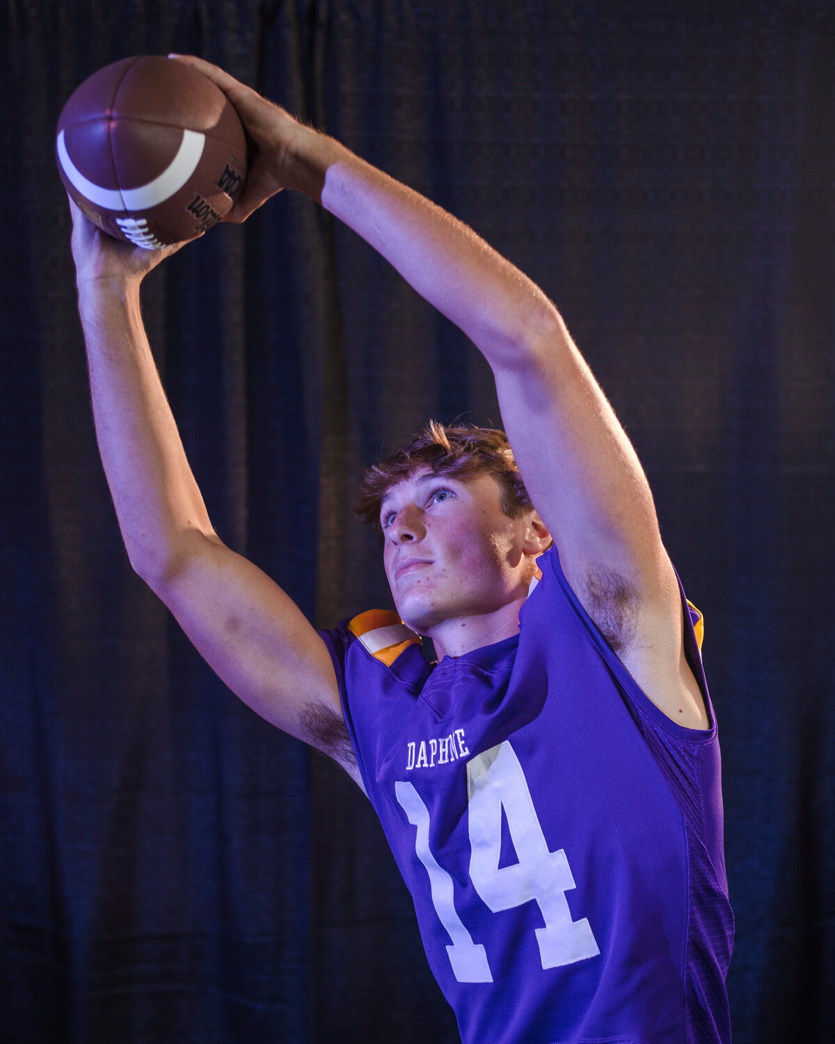 John Davis reaches for a catch during the portrait session following the Daphne Trojans’ interview as part of Gulf Coast Media Day in Orange Beach on July 27.