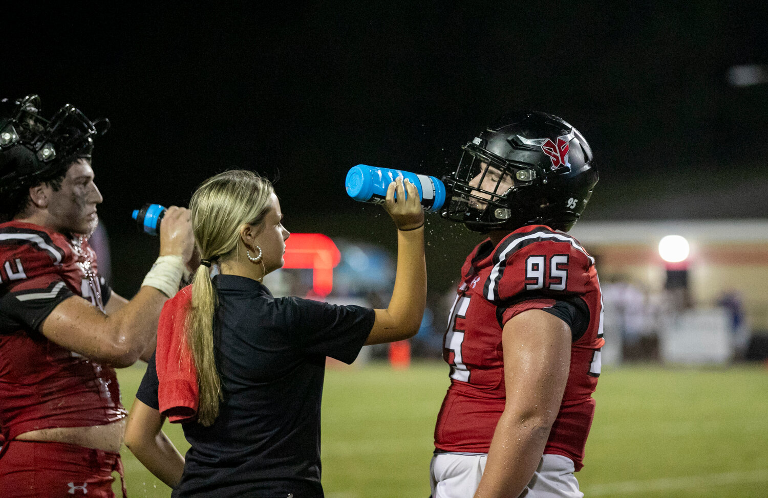 Spanish Fort’s Grey Freeman (95) and Newton Gardner (24) hydrate during a water break Thursday night in the Toros’ season opener against Fairhope. Amidst the heatwave being experienced in Alabama, extra timeouts were built into the game.