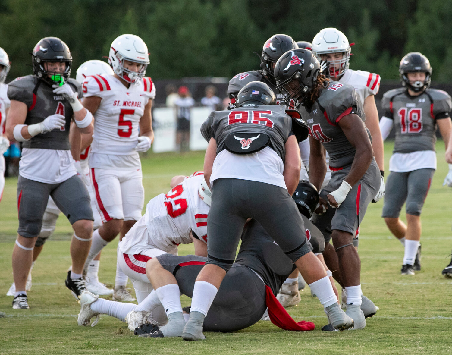 The Spanish Fort defense, including Sterling Dixon (10) and Grey Freeman (95), celebrate a stop in the first half of the preseason jamboree between the Toros and St. Michael Cardinals on Thursday, Aug. 17. Dixon was recently one of three Alabamian linebackers named to the High School Butkus Award watch list that is awarded to the top linebacker in the game at both the college and high school level.