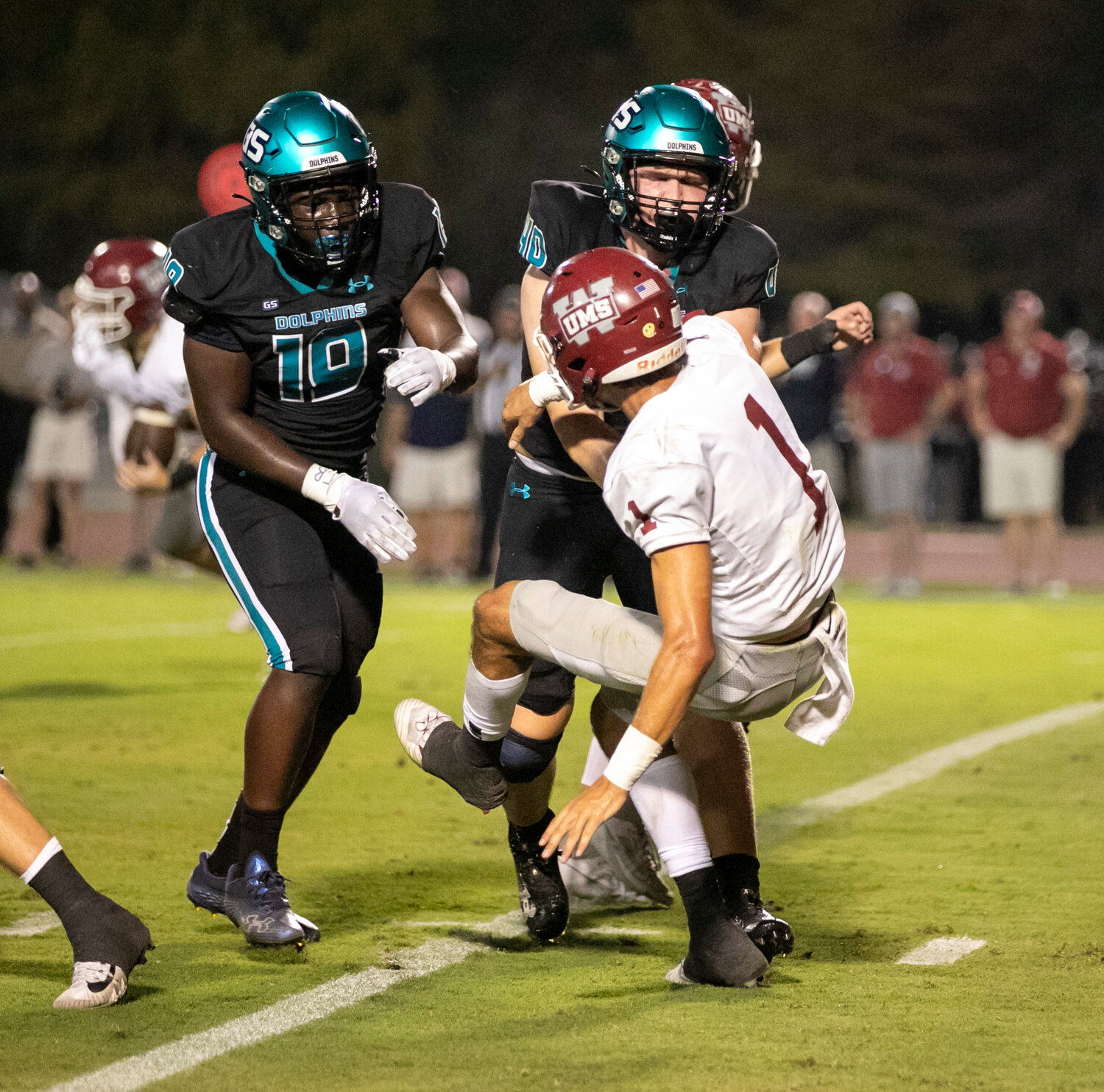 Gulf Shores’ Otto Brewer (40) and Jordan Watson (19) provide pressure on UMS-Wright’s Joe Lott (1) during the first half of Friday’s region battle at the Gulf Shores Sportsplex. The Dolphins’ defensive front dialed up the blitzes all night and earned a 17-0 shutout of the sixth-ranked Bulldogs.