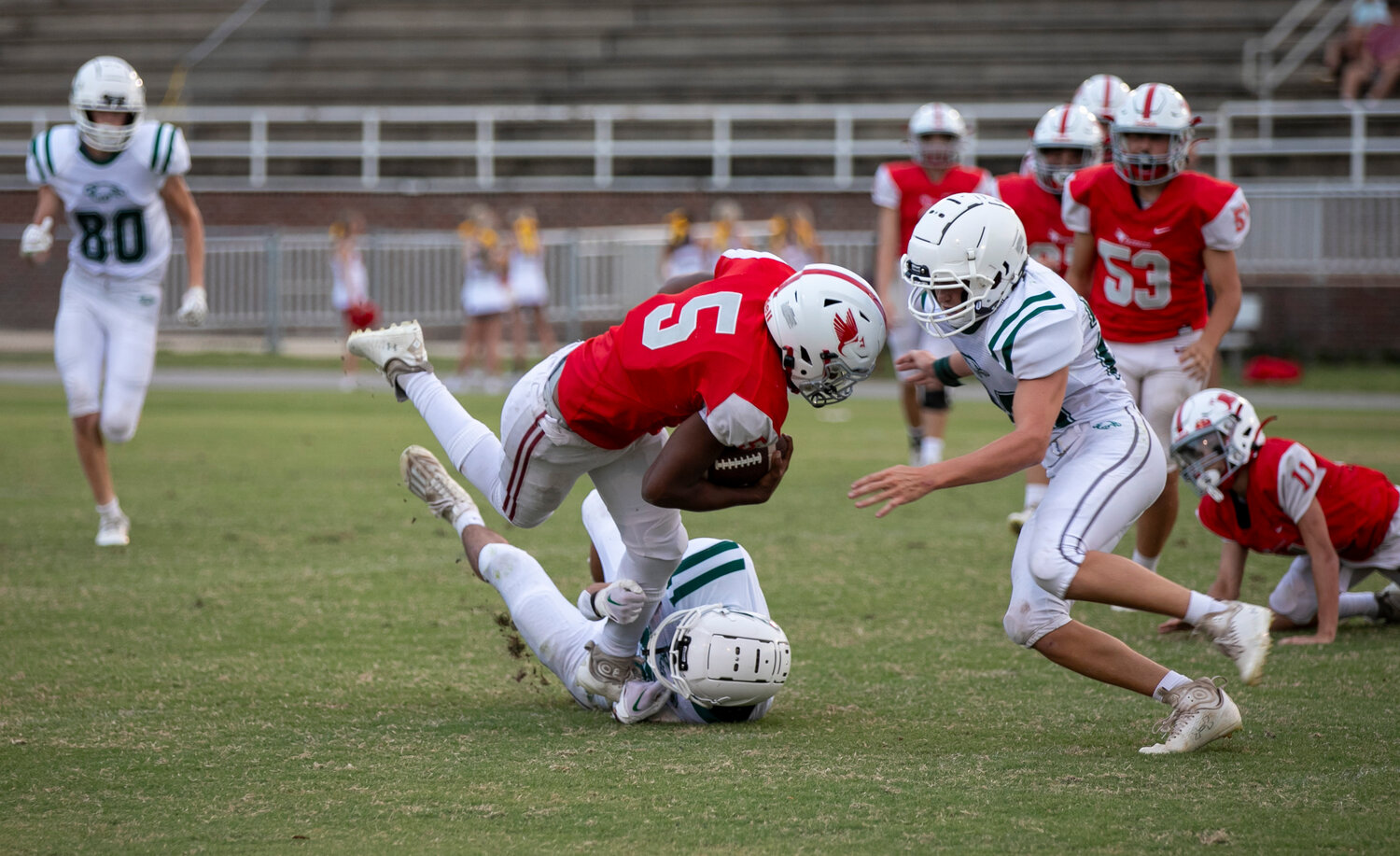 Bayshore Christian sophomore Andrew Hope (5) and junior Cyrus Dorsey (20) team up for a tackle of a St. Michael ballcarrier in the first half of action between the Eagles and Cardinals at Fairhope Municipal Stadium.