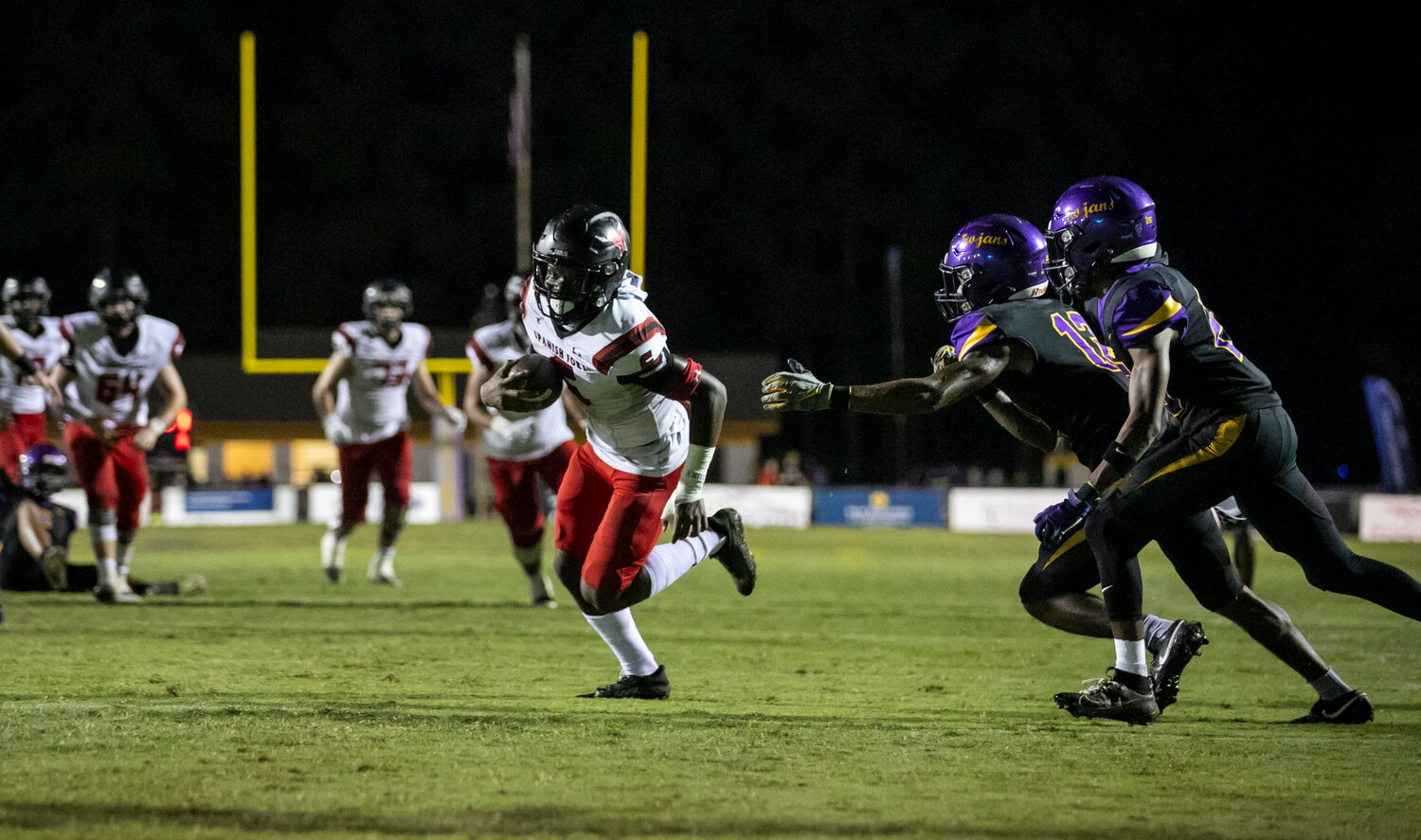 Justin Bonner evades a pair of Daphne defenders and eyes the goal line on his second of two touchdown catches from sophomore Aaden Shamburger during Spanish Fort’s 35-27, comeback win over the Trojans on the road Friday night.