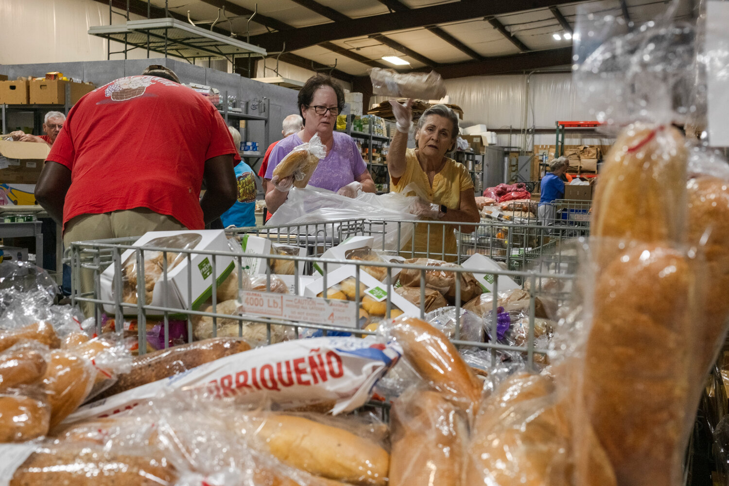 Volunteers at Prodisee Pantry in Spanish Fort organize bread items on Monday morning.