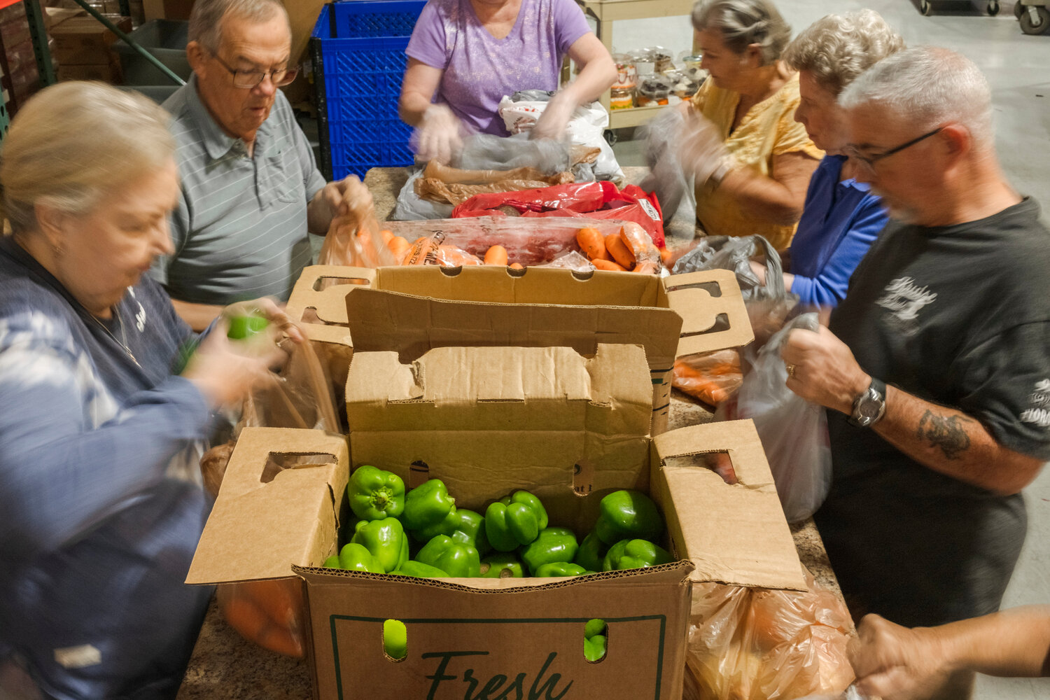 Volunteers at Prodisee Pantry in Spanish Fort pack produce into bags on Monday morning.