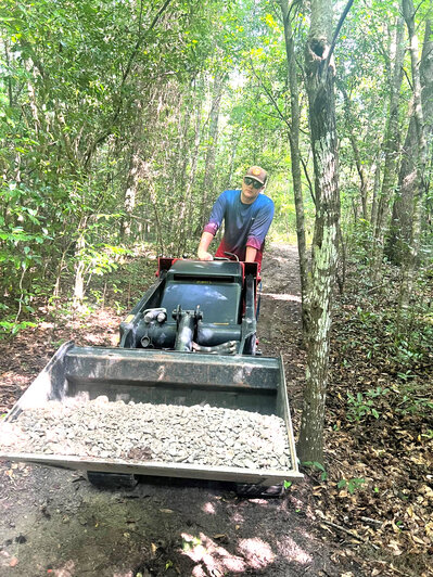 Eagle Scout Gabriel Hunter, of Daphne, moves gravel out to the trail around Jackon's Oak as part of his Eagle Scout project to revitalize the trail.