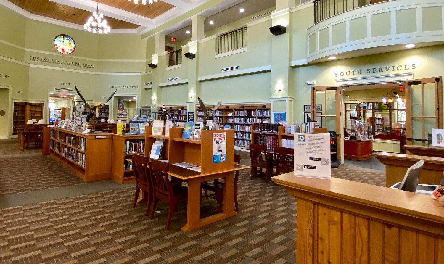 The main hall at the Fairhope Public Library. The Youth Library entrance is pictures on the right and the entrance to the Teen Library is at the far end under the stained glass window.