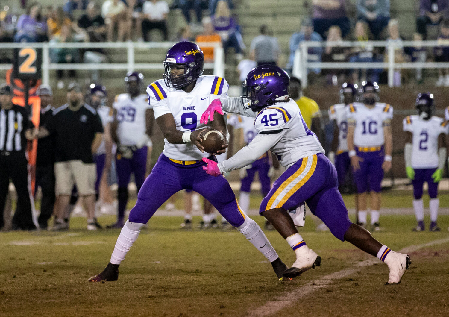 Daphne senior Nick Clark (45) goes through an exchange with quarterback Jamar Malone (9) during the Trojans’ region game against the Fairhope Pirates Friday night on W.C. Majors Field. The running back was recently recognized as one of six players from Baldwin County named to the North-South All-Star Football Classic set for December in Mobile.