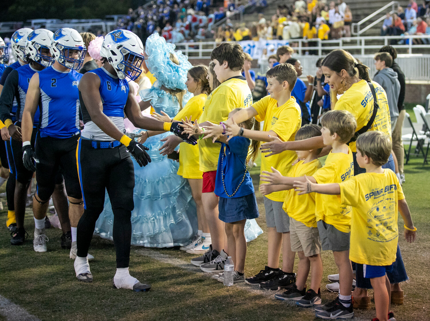 Desmond Thomas, Dallas Boothe and the Fairhope Pirates greet attendees of the 10th-annual Spina Bifida Awareness Game on Friday, Oct. 13, at Fairhope Municipal Stadium. After the tailgate during pregame warmups, the groups met for a handshake before the Pirates took on the Daphne Trojans.