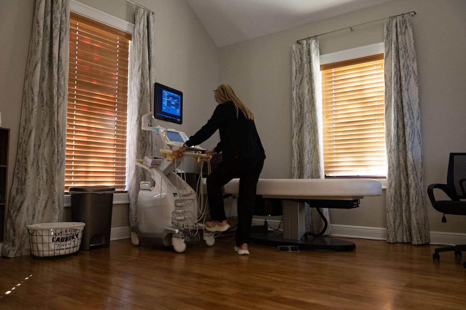 An employee at Women's Imaging Specialists in Fairhope preparing a room to complete an ultrasound on a patient.
