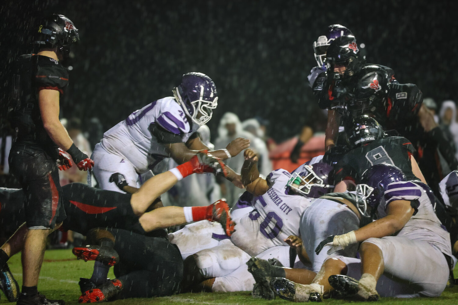 A group of Toros and Purple Tigers fight to gain control of the ball amidst the slippery conditions through Friday’s rain during the Class 6A State Playoff game between Spanish Fort and Bessemer City. The Toros earned a 28-0 win and improved to 11-0 at home in the first round.
