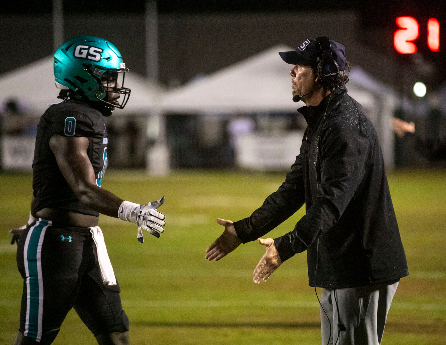 Dolphin defensive coordinator Brian VanGorder greets senior Kingston Lowe on the sideline after a Gulf Shores stop in the second half of first-round playoff action against the Beauregard Hornets at home on Friday, Nov. 10. The Dolphins’ 48-7 win finally put their average point allowance to double digits at 10.0 through 11 games.