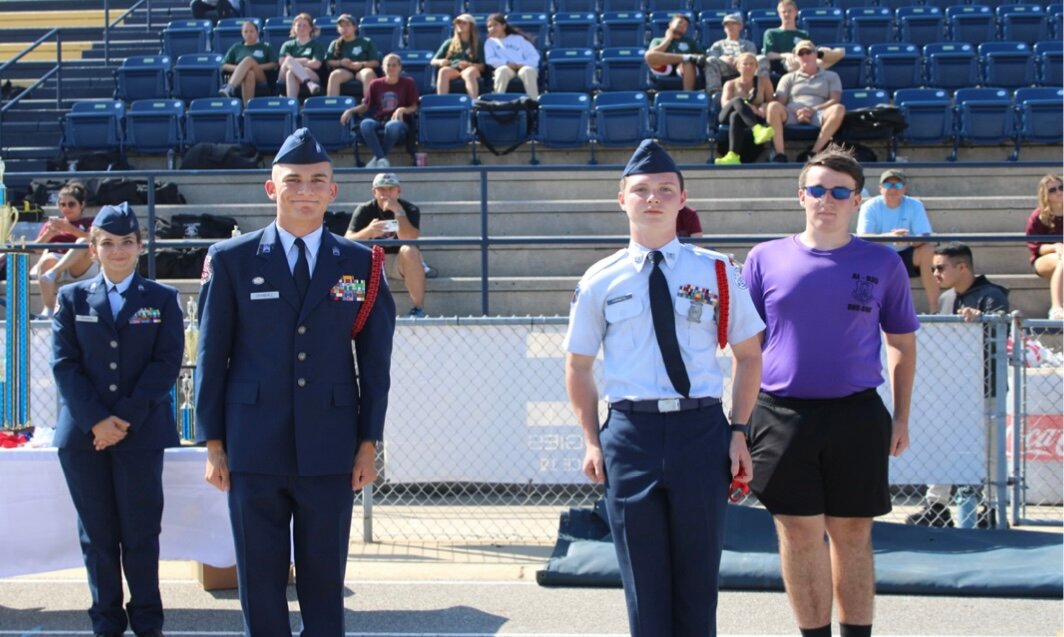 Cadet Forrestel, sophomore, gets a second place medal for his Individual Drill Routine, Also pictured is drill team commander, Cadet McFall, senior [in purple shirt.]