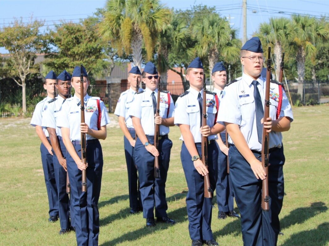 Members of the AL-935 Armed Drill Team, led by cadet Mercer, salute their judges before beginning the drill maneuvers.