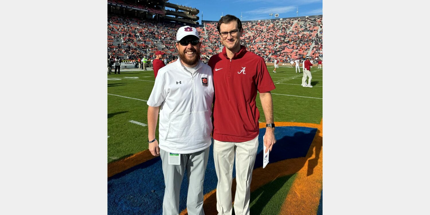 Fairhope alumni Will Reid and Ellis Ponder pose for a photo before the 88th installment of the Iron Bowl rivalry between Auburn and Alabama on Pat Dye Field at Jordan-Hare Stadium on Saturday, Nov. 25. The pair worked one season together for the Pirate football team before their respective graduations from Fairhope High School in 2009 and 2006. Reid now serves as the Director of Football Video at Auburn and Ponder is the Associate Athletics Director and Football Chief Operating Officer at Alabama.
