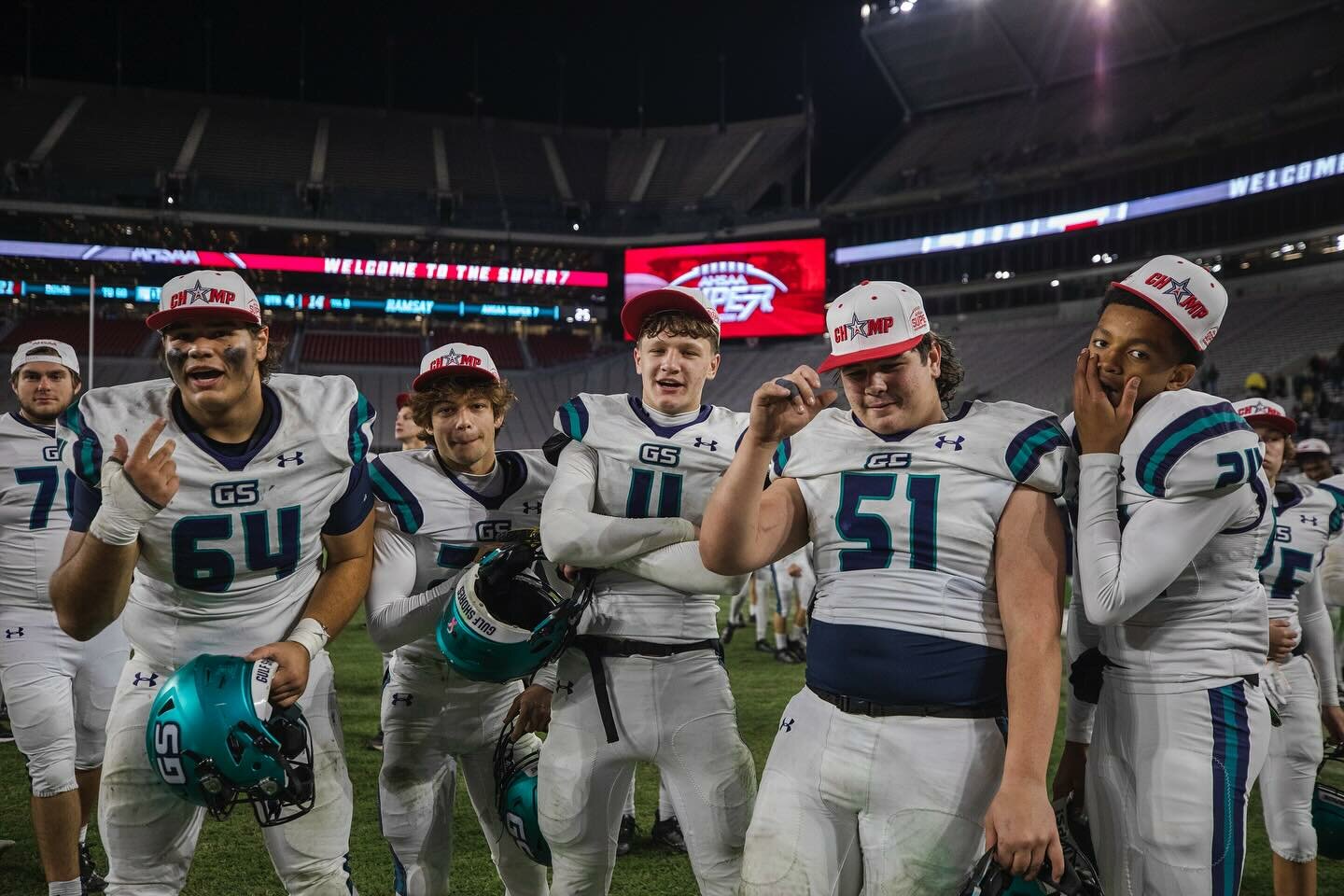 Dolphin football players including Sam Schepker (64), Will Langston (27), Carter Byrd (4), Brantley Akins (51) and Jonathan Jackson (24) celebrate the 21-14 win over Ramsay that crowned Gulf Shores as Class 5A state champions at Bryant-Denny Stadium on Thursday, Dec. 7. The 2023 Dolphin team became the first in program history to finish a season undefeated at 15-0.