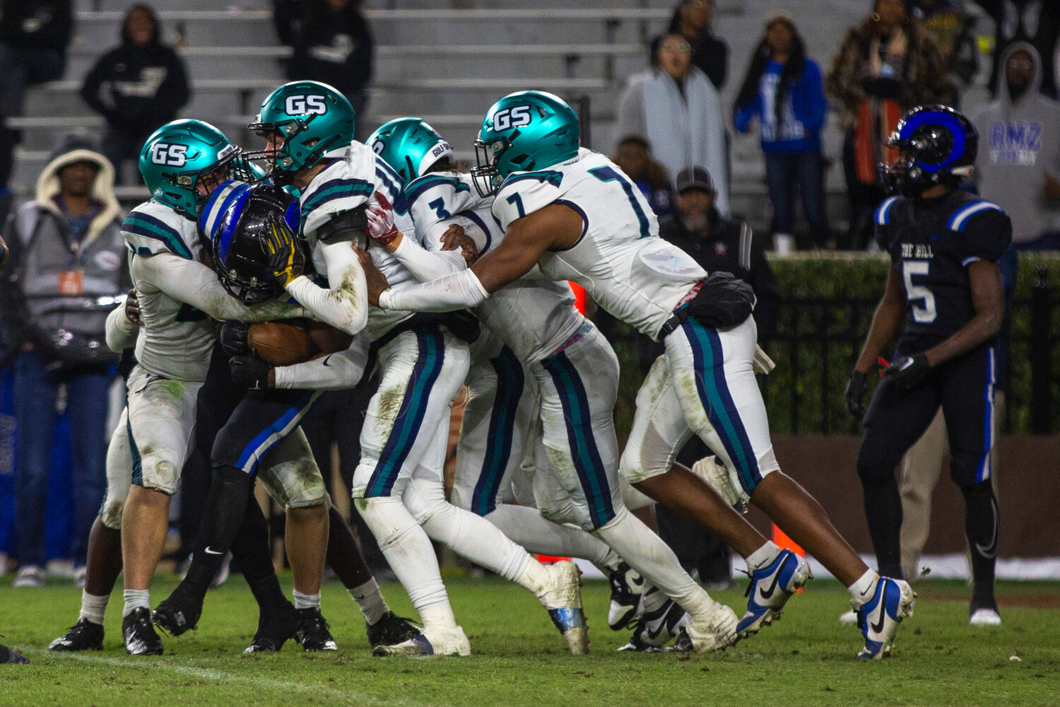 A pod of Gulf Shores Dolphins, including Landon Everett (20), Carter Byrd (4), Blaize Thomas (3) and Jamichael Garrett (7), converge for a stop on a Ramsay ballcarrier during the Class 5A state championship game at Bryant-Denny Stadium on Thursday, Dec. 7. The Gulf Shores defense set a program record for fewest points allowed in a season as part of five shutout efforts.