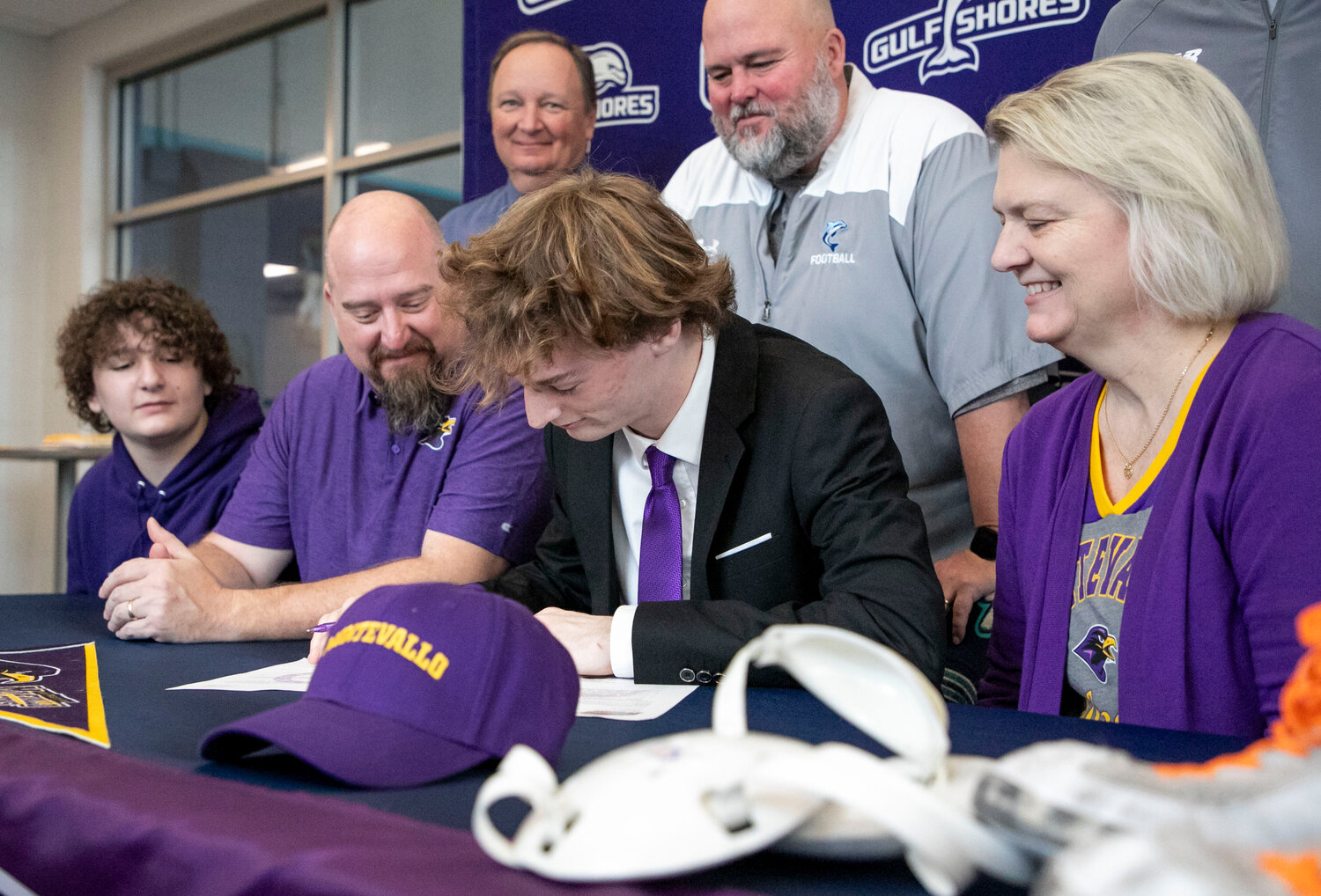 Gulf Shores senior Ethan Sharkey puts pen to paper on his National Letters of Intent to wrestle and run outdoor track for the Montevallo Falcons during a signing ceremony at the high school on Wednesday, Jan. 24. A three-sport athlete for the Dolphins, Sharkey looked forward to his next challenge of playing multiple sports at the collegiate level.