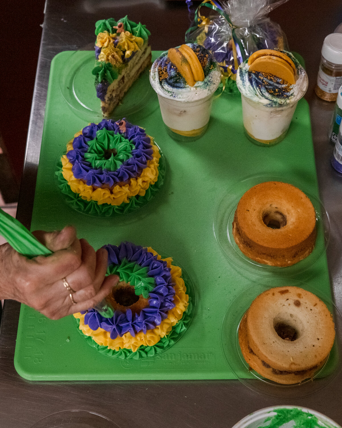 Sonja Dowdle decorates a king cake pound cake at Market By The Bay.