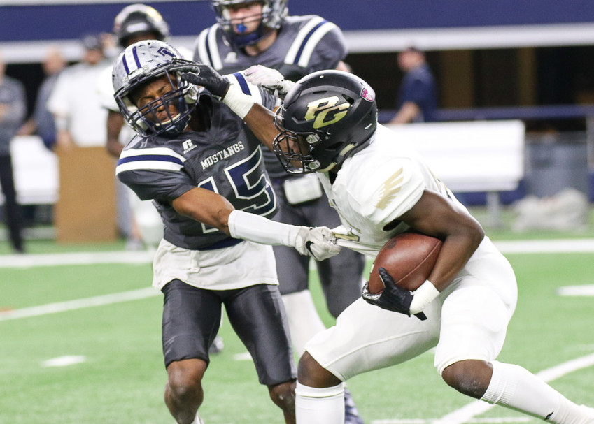 Pleasant Grove Hawks senior running back Chauncey Martin (21) delivers a stiff arm to West Orange-Stark Mustangs senior Jarron Morris (15) during the UIL Class 4A Division II state football championship game between West Orange-Stark High School and Pleasant Grove High School at AT&amp;T Stadium in Arlington, Texas, on December 22, 2017.