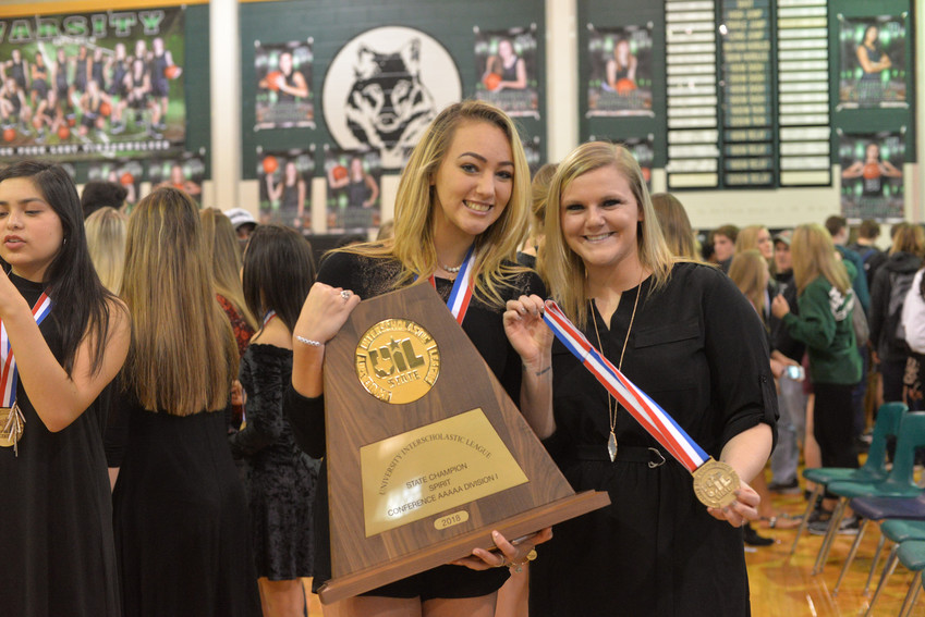 Cheerleading captain Sabrina Enriquez and coach Morgan Maddux celebrate with the state UIL Championship trophy.