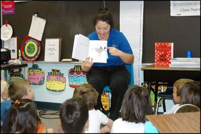 Cafeteria employee Clara Ramos reads &lsquo;Ferdinand the Bull&rsquo; to a group of students at Whitestone Elementary. Elementary schools throughout Leander ISD read books on Sept. 20, 2017, as part of the Reading for the Record program.