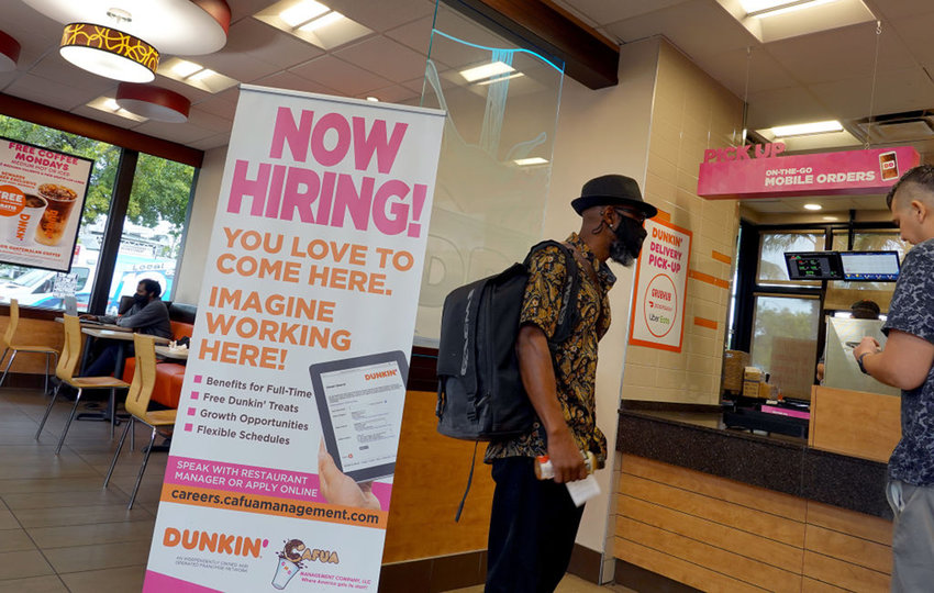 A &quot;Now Hiring&quot; sign is displayed at a Dunkin' restaurant on Sept. 21, 2021 in Hallandale, Florida. (Joe Raedle/Getty Images/TNS)